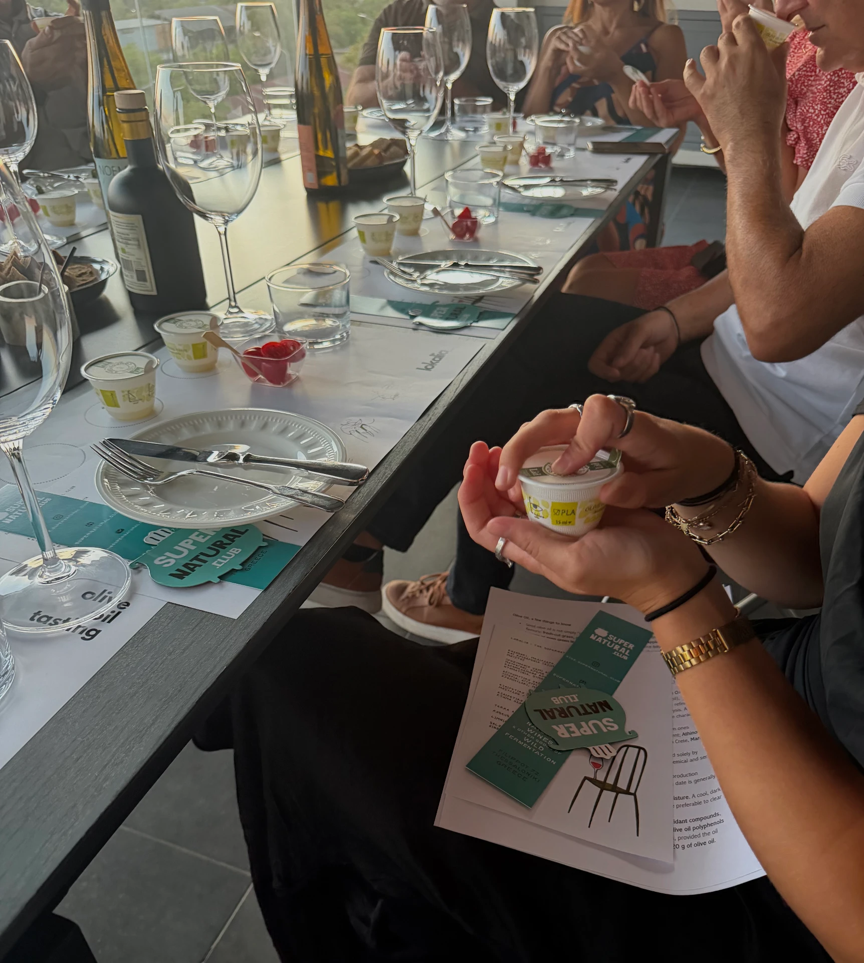 guests sampling olive oil around the long table