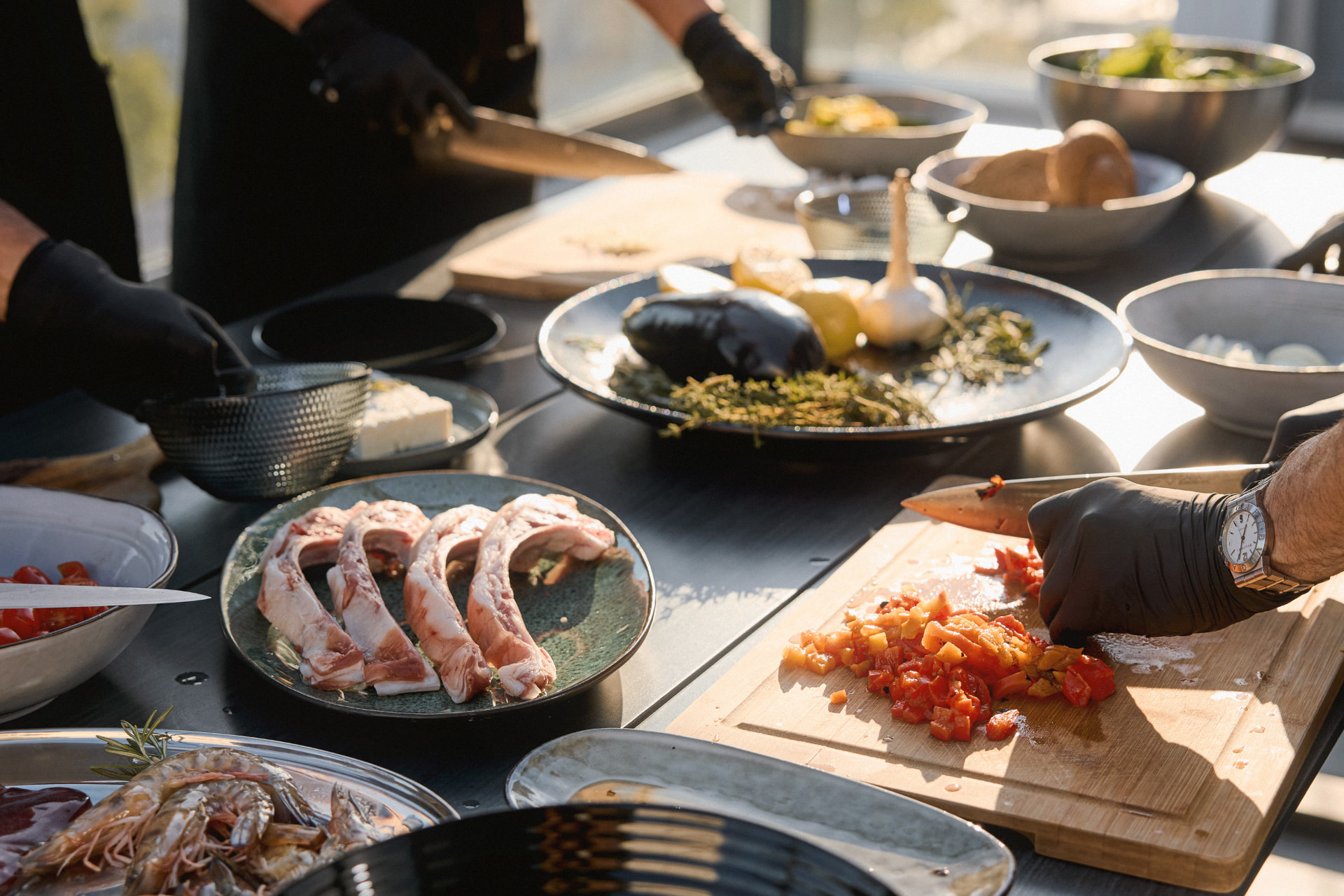 ingredients laid out on the table as guests prep the evening's dishes in golden light